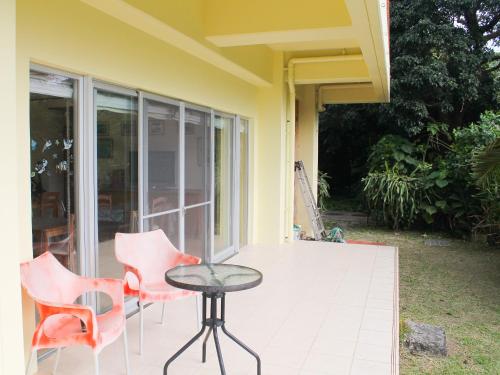a patio with chairs and a table on a porch at Pine Shima Resort Coral Fish in Ibaruma