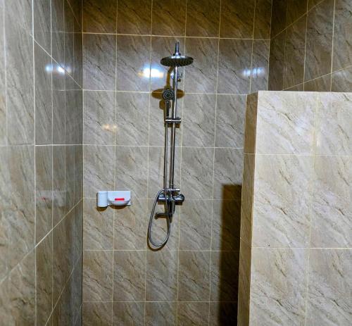 a shower with a shower head in a bathroom at Madesimon Villa Apt in Payangan