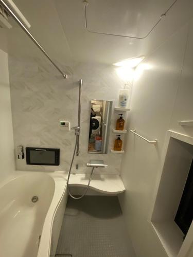 a white bathroom with a tub and a sink at Miaoyi Asakusa in Tokyo