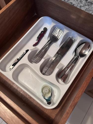 a white sink with utensils in a drawer at Brand New Beachfront Sunset Apartments in San Felipe de Puerto Plata