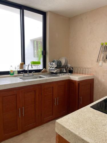 a kitchen with a sink and a window at Casa colibrí in Río Lagartos