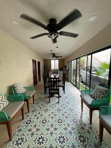 a living room with chairs and a ceiling fan at Casa colibrí in Río Lagartos