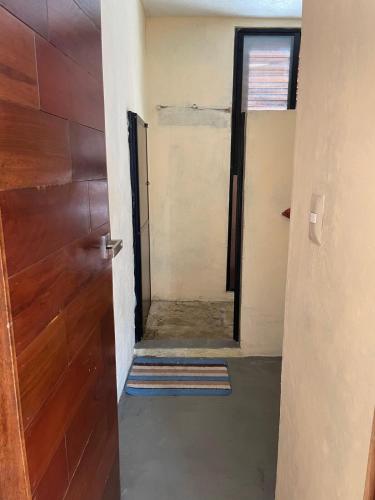 a hallway with a door and a mirror at Casa colibrí in Río Lagartos