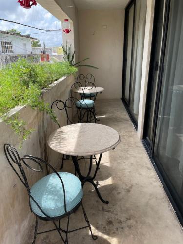 two tables and chairs sitting on a balcony at Casa colibrí in Río Lagartos
