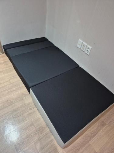 a corner of a room with a black floor at Andong Poong-gyung HOSTEL n LIBRARY in Andong