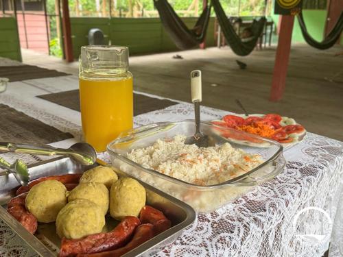 a table with a tray of food and a glass of orange juice at Estación Biológica Santa María de Fátima II Zona in Iquitos