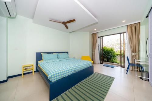 a bedroom with a blue bed and a green rug at Allamanda Laguna Phuket in Laguna Phuket