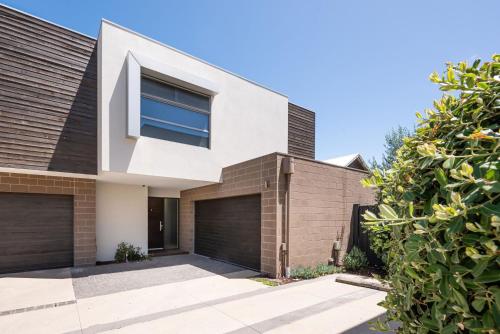a modern house with a brick wall at Gracie on the Beach Luxe with Water Views in Edithvale