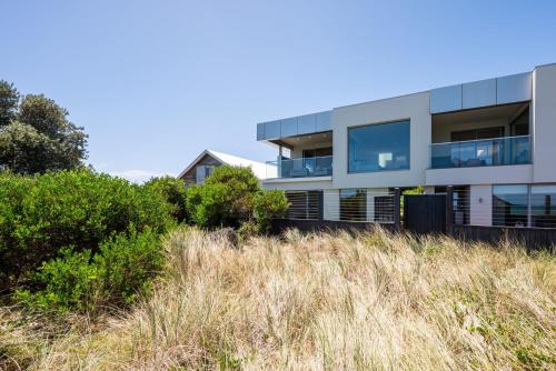 a building on top of a hill with grass at Gracie on the Beach Luxe with Water Views in Edithvale