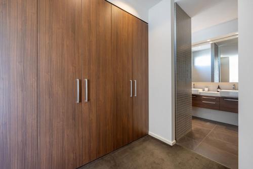 a bathroom with wooden cabinets and a sink at Gracie on the Beach Luxe with Water Views in Edithvale