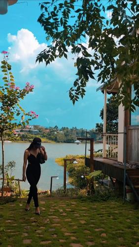a woman taking a picture of a lake with a camera at Nhà Bên Hồ- The Peace's House in Bao Loc