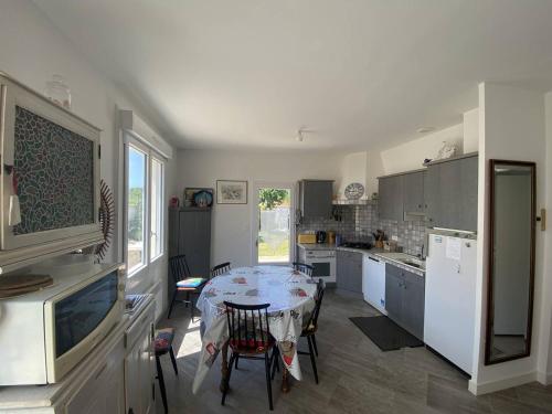 une cuisine avec une table et quelques chaises dans l'établissement Villa T4 à Vaux-sur-Mer, proche plages, jardin et terrasses - FR-1-738-42, à Vaux-sur-Mer