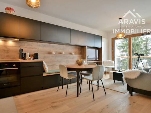 une cuisine et une salle à manger avec une table et des chaises dans l'établissement Appartement moderne avec vue sur les pistes et cuisine équipée - FR-1-391-201, au Grand-Bornand