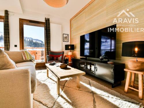 un salon avec un canapé et une télévision dans l'établissement Chalet confortable avec balcon, garage et vue sur les pistes - FR-1-391-202, au Grand-Bornand
