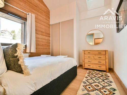- une chambre avec un lit, un miroir et une commode dans l'établissement Chalet confortable avec balcon, garage et vue sur les pistes - FR-1-391-202, au Grand-Bornand