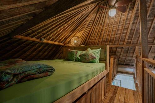 a bedroom with a bed in a thatched room at Le Yanandra Bali Resort in Jimbaran