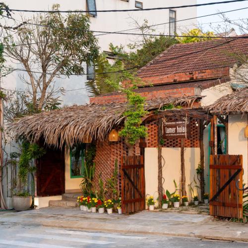 an old building with a thatch roof at Lamer Coastal Villa in Hoi An