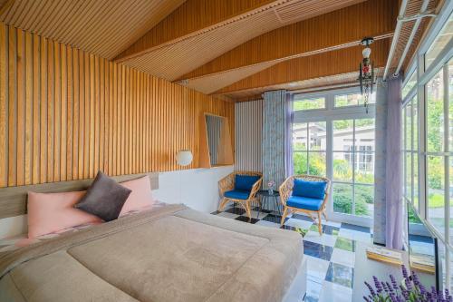 a bedroom with a bed and two blue chairs at La Cle' Đà Lạt in Da Lat
