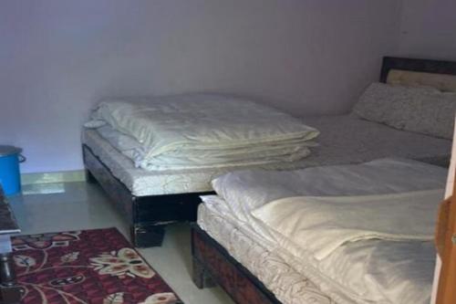 a room with three beds and a rug at Amardeep Homestay by StayApart in Ukhimath