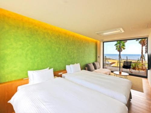 a bedroom with two beds and a view of the beach at そらすな Beach Side Resort Hotel in Yukuhashi