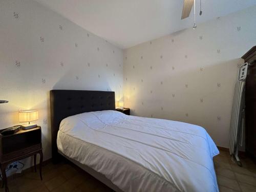 - une chambre avec un lit blanc et 2 tables de chevet dans l'établissement Appartement climatisé 2 pièces avec WIFI à Cavalaire-sur-Mer, parking inclus - FR-1-226B-222, à Cavalaire-sur-Mer