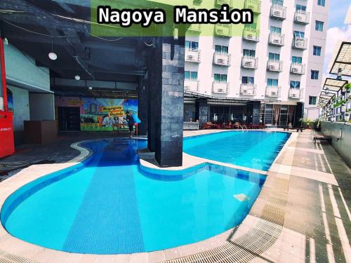 a large blue swimming pool in front of a building at Nagoya Mansion Apartment by Homestay81 in Nagoya