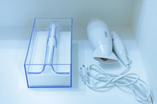 a white electric hair dryer and a box with a wire at コテージいっぺき湖 in Ito