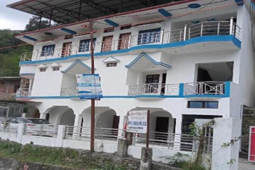 a white building with blue trim at Vijaya Palace by StayApart in Gupta Kāshi