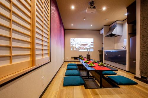 a dining room with a long table and blue chairs at Ukiyoan Takasago in Tokyo