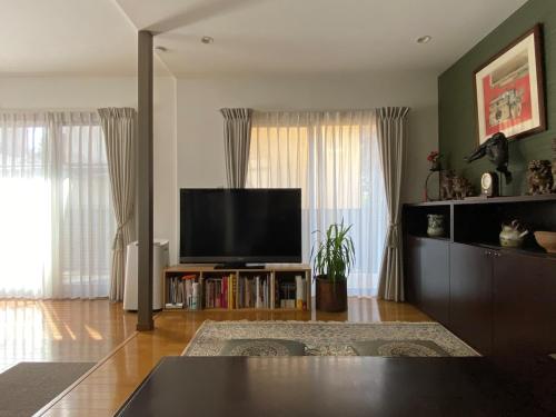 a living room with a flat screen tv on a stand at 湘南ソラル2nd 最大8名一棟貸切 犬OK 駅近 ビーチ近 観光に最適 in Ninomiya
