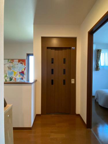 a hallway with a wooden door in a bedroom at 湘南ソラル2nd 最大8名一棟貸切 犬OK 駅近 ビーチ近 観光に最適 in Ninomiya