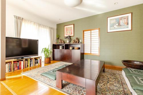 a living room with a tv and a coffee table at 湘南ソラル2nd 最大8名一棟貸切 犬OK 駅近 ビーチ近 観光に最適 in Ninomiya