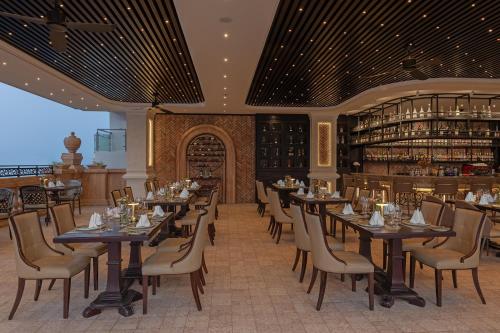 a restaurant with tables and chairs and a bar at Anik Palace Hotel in Phnom Penh