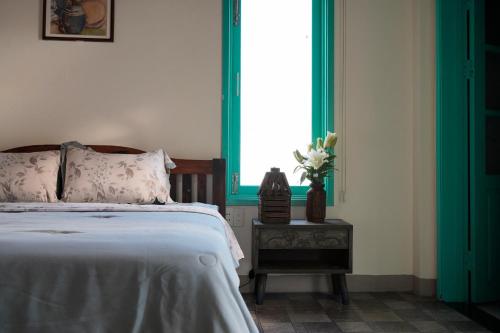 a bedroom with a bed and a vase of flowers on a table at Lamer Coastal Villa in Hoi An