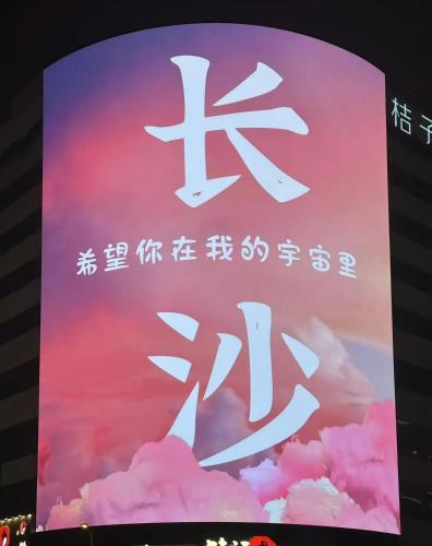 a sign with chinese writing on it with a cloudy sky at Anya Hotel -Next to Jiefang West Bar Street 2 minutes to the subway station free coffee free laundry free gym, huge windows in Changsha