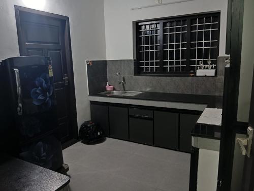 a small kitchen with a sink and a window at Licence To Chill Homestay Villa in Pūvār