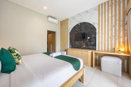 a bedroom with two beds and a tv on a wall at Cove Arganta in Dalung