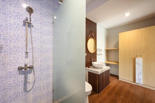 a bathroom with a shower and a toilet and a sink at Cove Arganta in Dalung