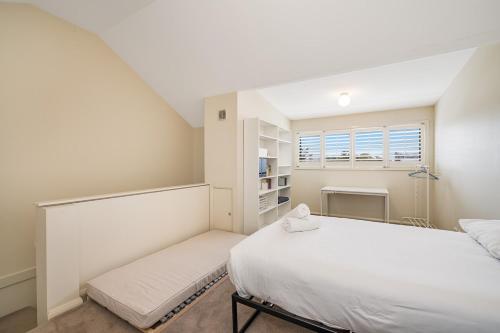 a white bedroom with two beds and a window at Riverside in Maryville
