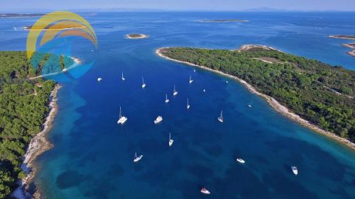 a paraglider flying over a group of boats in the water at Ferienwohnung für 2 Personen ca 30 qm in Premantura, Istrien Istrische Riviera in Premantura