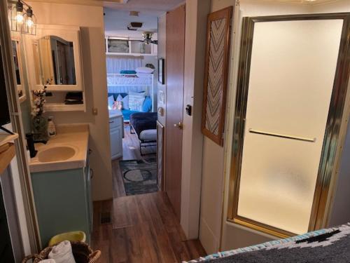 a bathroom with a sink and a door to a room at Rustic Farm meadow stay in Temecula