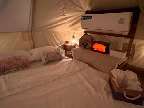 a bedroom with a white bed with a small box on it at มาค่ะ ฟาร์มสเตย์ ห้วยเขย่ง สวนคุณตา สวนทุเรียนทองผาภูมิ in Ban Diso