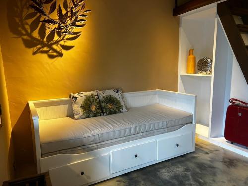 a white bench in a room with a yellow wall at 池上包棟民宿-莊稼熟了三館 in Chishang