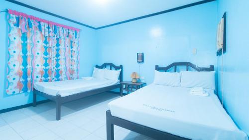 Ένα ή περισσότερα κρεβάτια σε δωμάτιο στο Villa Del Carmen Resort & Restaurant by RedDoorz