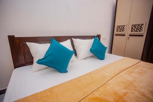a bedroom with a bed with blue and white pillows at Sunset View Galle in Pedinnoruwa
