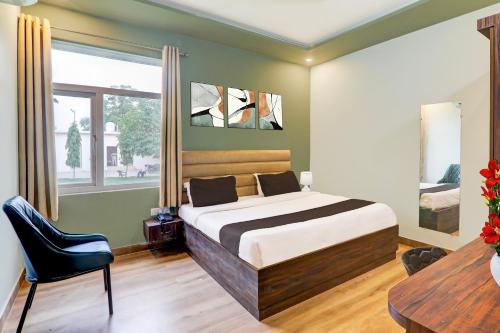 a bedroom with a bed and a desk and a chair at Super Hotel O Gomti Nagar Vigyan khand in Lucknow