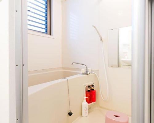 ein weißes Badezimmer mit Badewanne und Waschbecken in der Unterkunft F House Os Residence S2 in Osaka