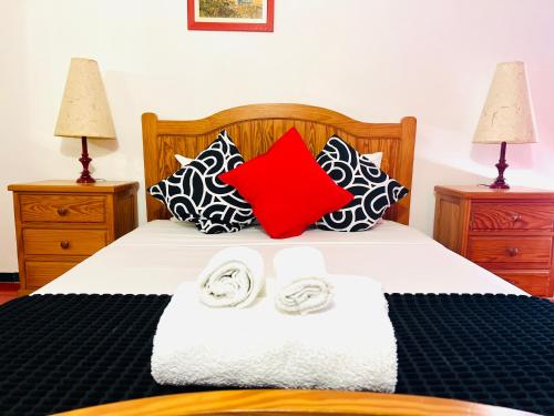 una camera da letto con un letto con due asciugamani e cuscini di Point Apartament Praia da Oura ad Albufeira
