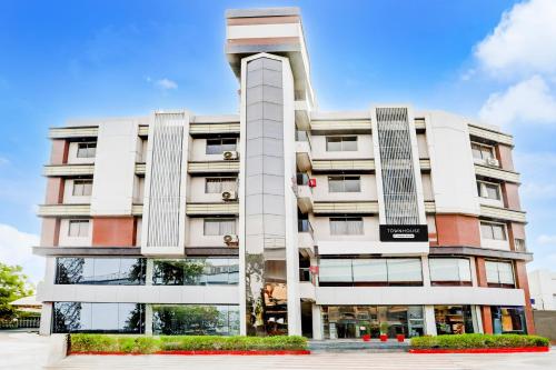 a tall white building with a lot of windows at Super Townhouse Prahladnagar in Ahmedabad