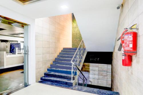 a staircase in a building with a fire extinguisher at Super Townhouse Prahladnagar in Ahmedabad